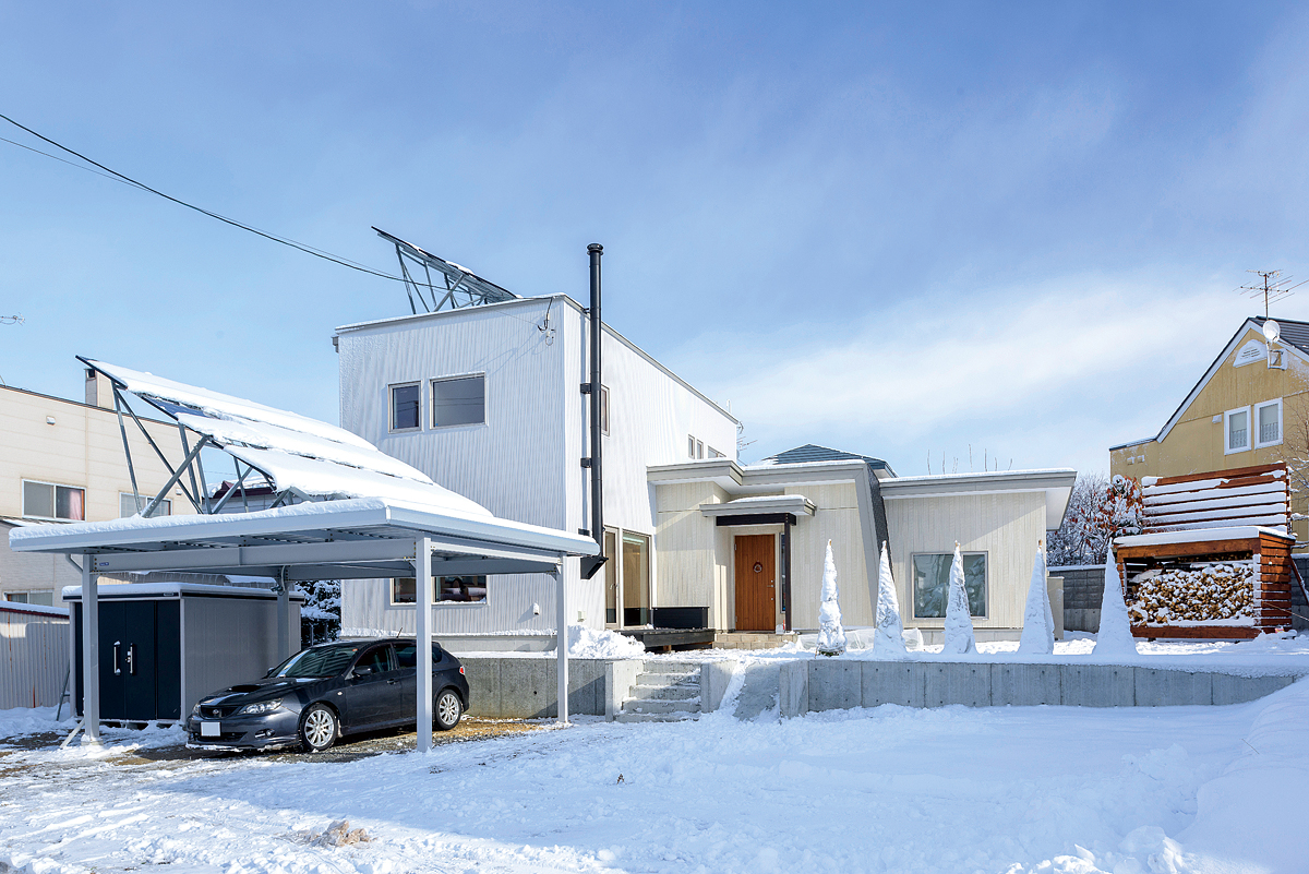 建物は、白を基調にシンプルですっきりとまとめて。カーポートと建物の屋根には7.8kWの太陽光パネルが搭載されている
