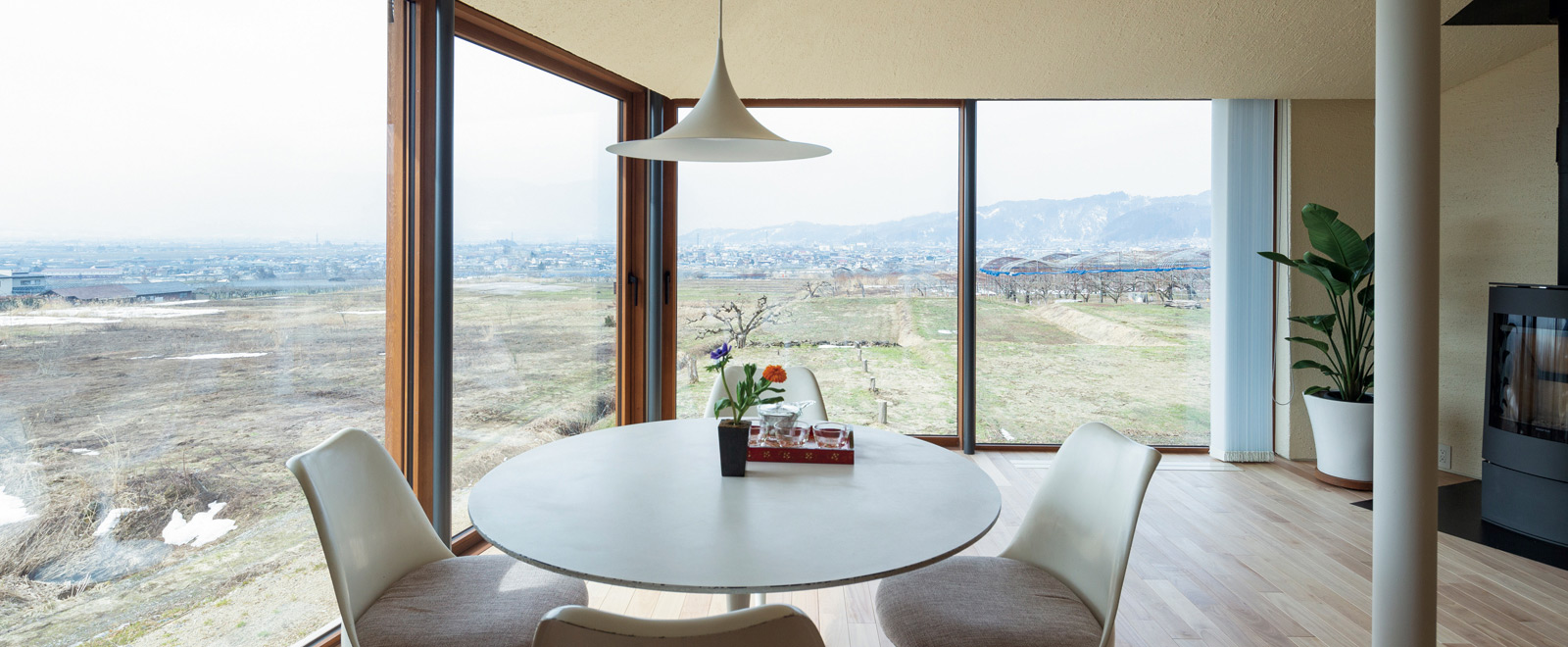 緩やかな傾斜のある小高い土地で、敷地の突端側に建物を配置。傾斜側は用水路のある畑が広がっていることから、外からの視線を気にすることなく景観を楽しめるため、リビング・ダイニングの開口部を最大限に確保したプランに