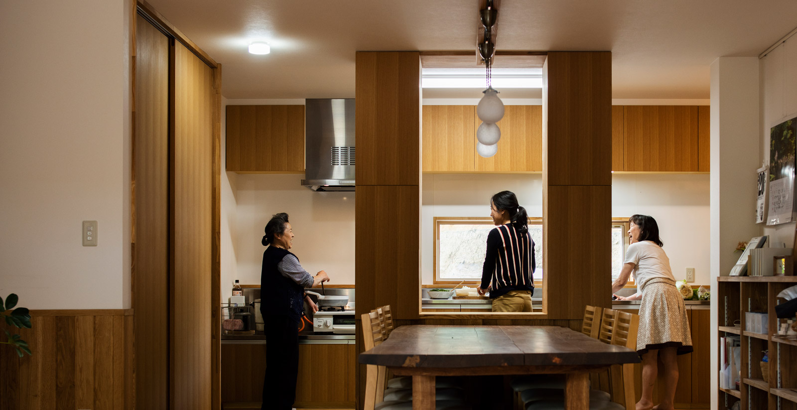 3世代で立っても、まだ余裕のある広いキッチン。ダイニングとの間仕切りにもなっている造作カウンター収納は、裏表に細々したものが仕舞える。無垢のエンジュでつくられた食卓テーブルは、Nさんが「将来の新築のために」と20年以上前に買ってしまってあったもの。大人8人がゆったり座れるテーブルは、木が好きなNさん一家の新居のシンボルになった