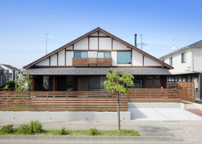 外観南側正面。大屋根の中に2階建ての建物がすっぽ りと入るようなフォルム。スギの板塀が昔ながらの日本家屋を彷彿とさせる