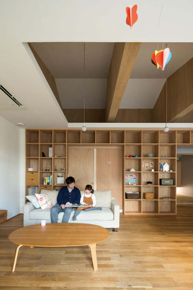 リビングはゆとりのある空間とし、背面には見せる収納を一面に配置。収納のグリッドは無印良品のBOXをモジュールにしている