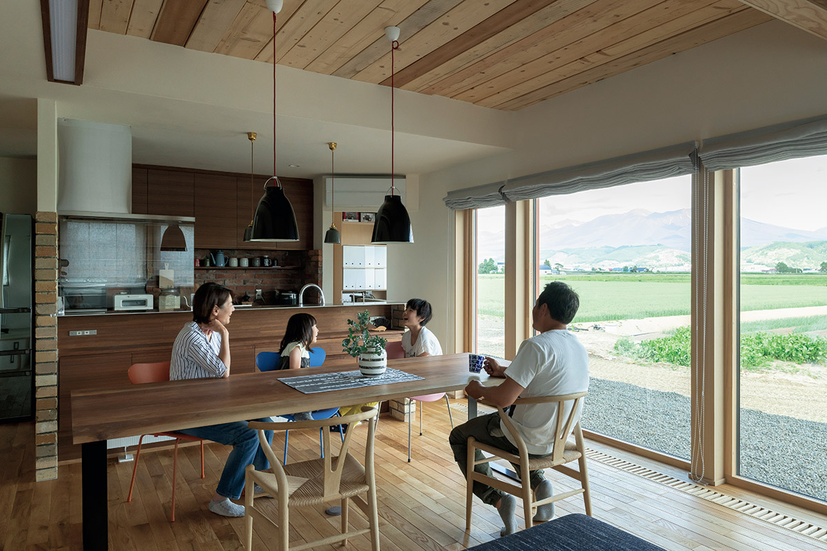 対面キッチンのダイニング側に棚を造作した例。コンセントも2口設置されていて、スマホの充電やホットプレートなどを使うのにも重宝する