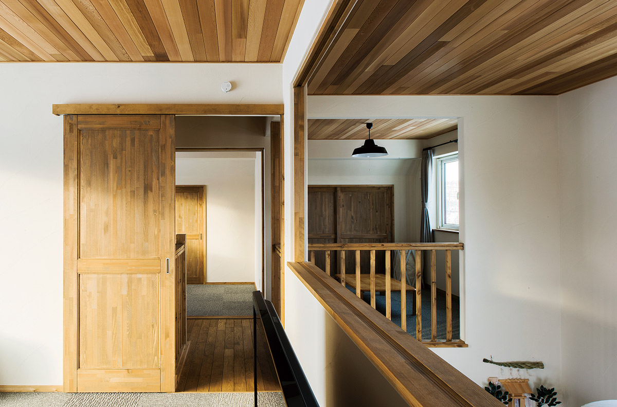 吹き抜けに面してしつらえた子ども部屋はあえて建具を入れず、階下にいても互いの気配が伝わるようにした