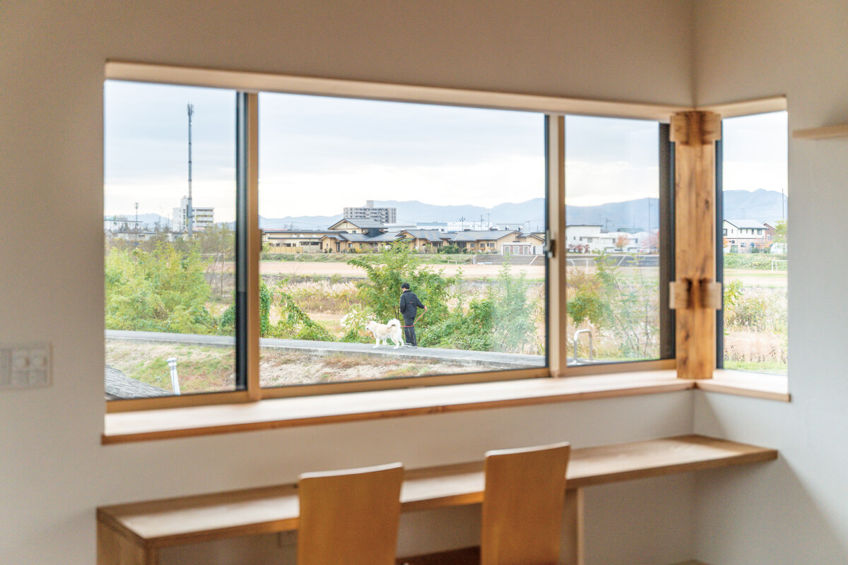 河川敷の風景を取り込むように設けた出窓。造作カウンターからは、季節の移ろいとステイホームを楽しめる