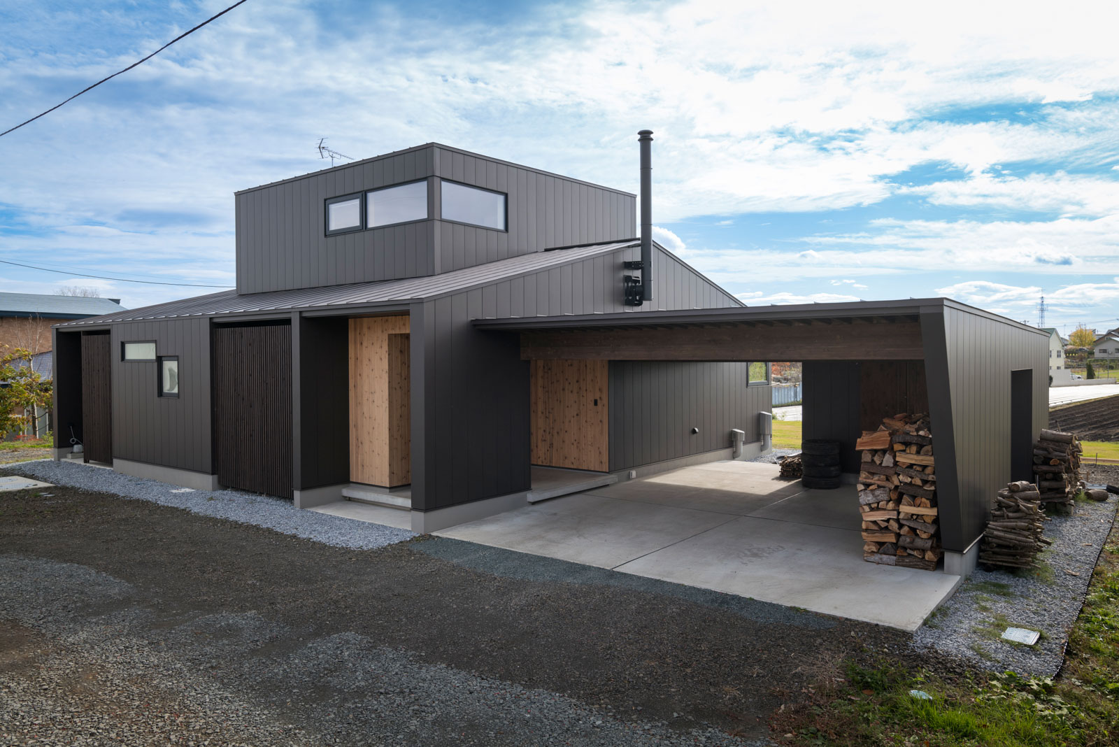 切妻屋根の1階に箱型の2階をバランス良く配置。カーポートと外部収納を住まいと一体化させることで外観のデザイン性を高めた