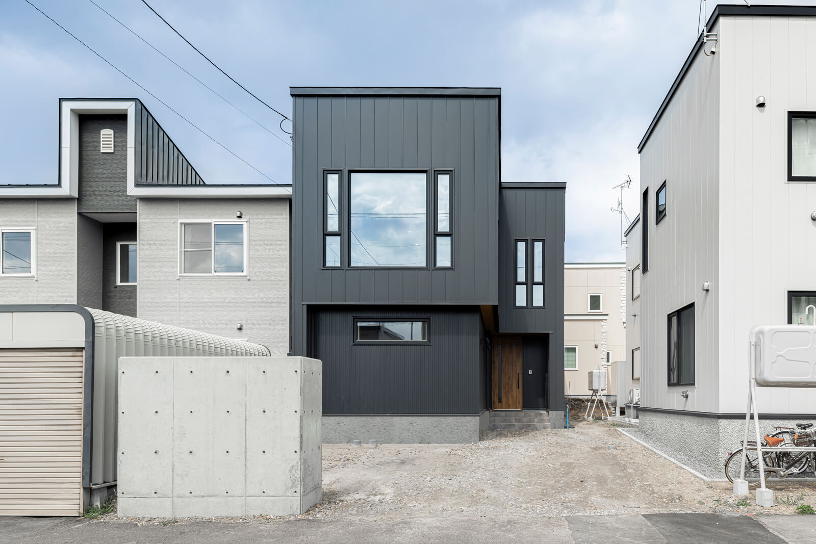 シックな色合いのガルバリウム鋼板を採用したシャープな印象の外観。隣り合う家々や道路を行き交う車や人の目線を気にせず過ごせる2階にLDKを設けた