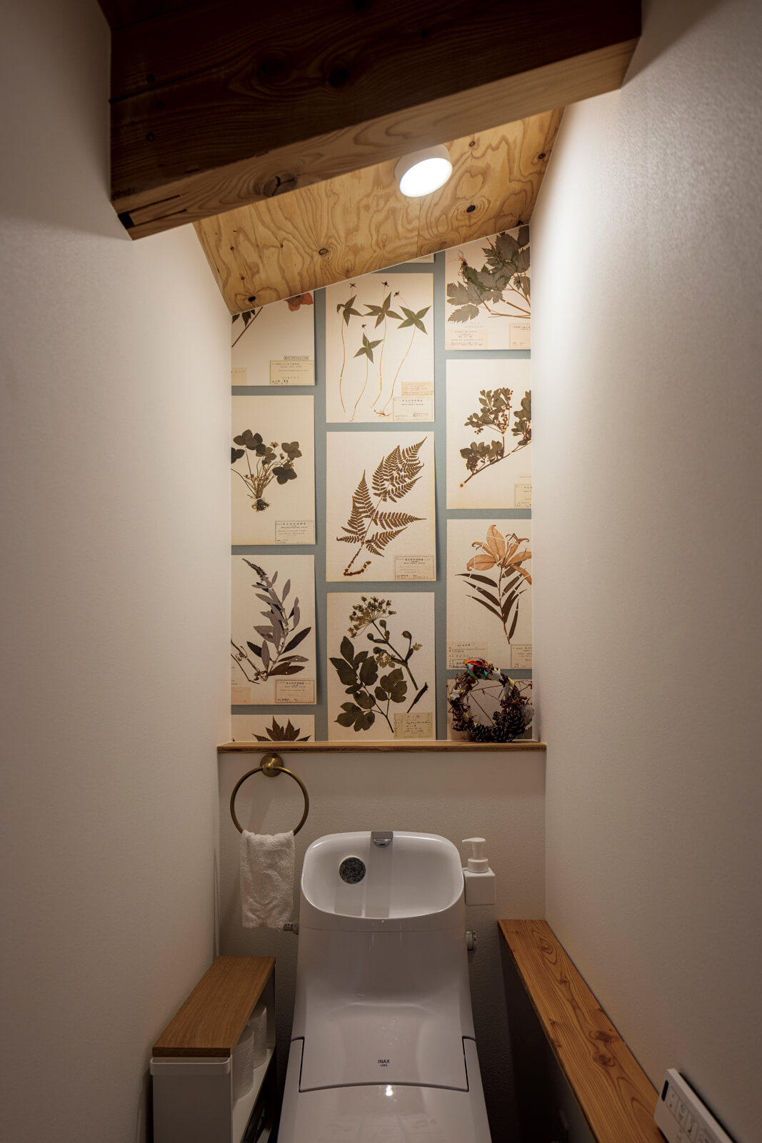 2階のトイレの壁には、奥さんが選んだ植物標本を描いたクロスを張り、遊び心ある設えに仕上げた