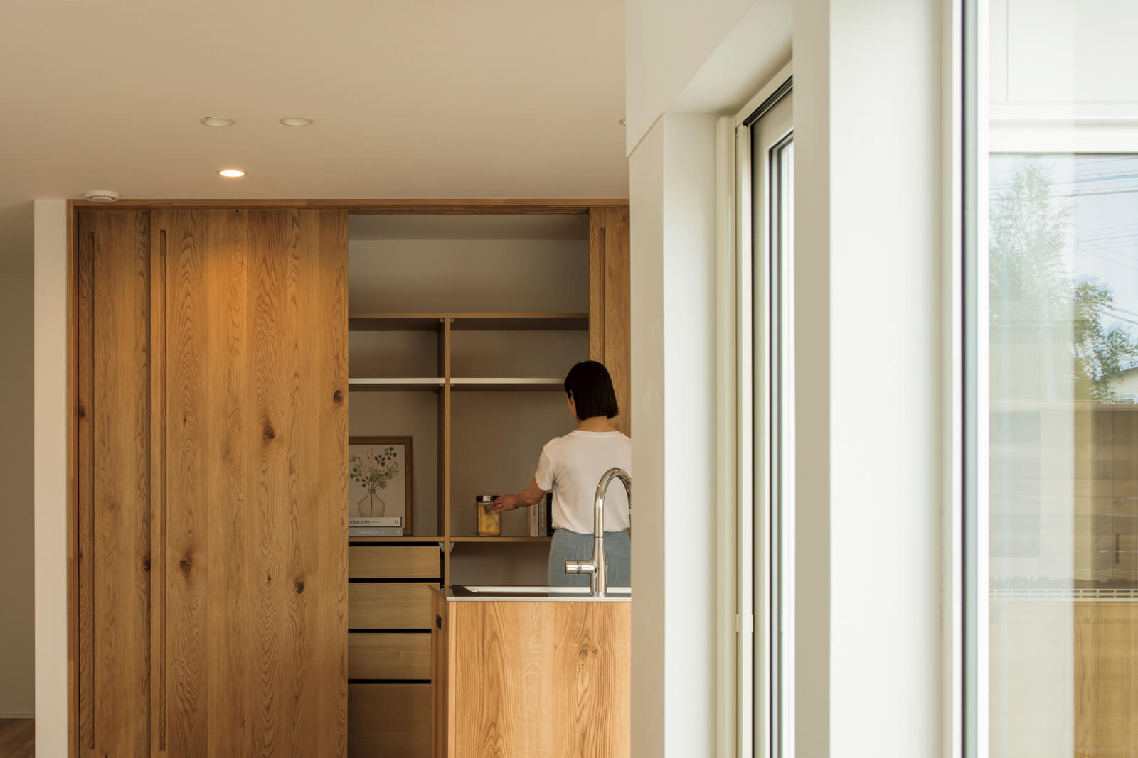 キッチンの背面収納は壁一面の大型。天井まである建具はぴったりサイズを合わせた造作で、統一感とデザイン性が秀逸
