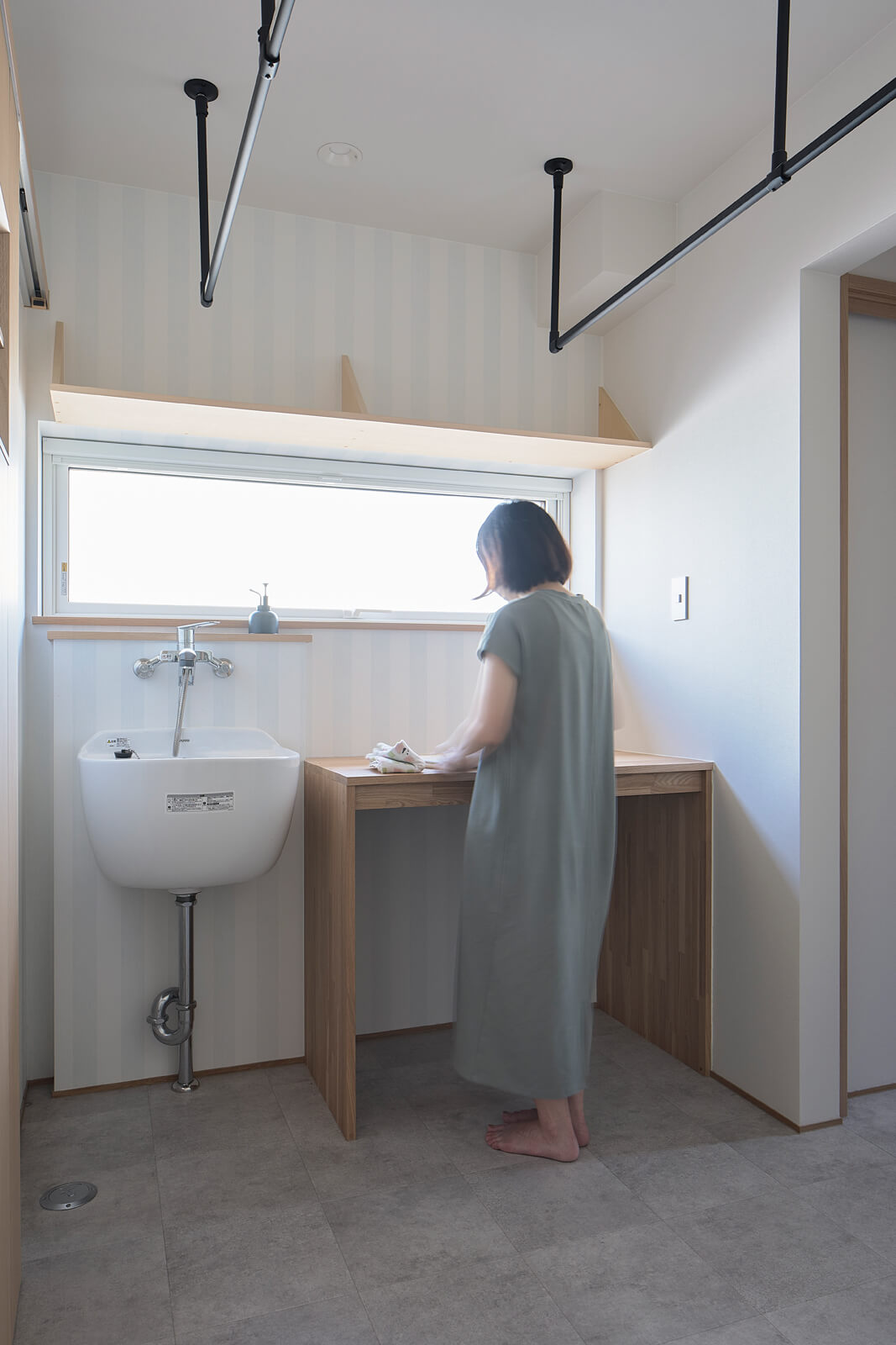 広々としたランドリールームには、スロップシンクと作業台を設置して洗濯作業をしやすく。ランドリールームの左右に浴室と洗面スペースが位置する