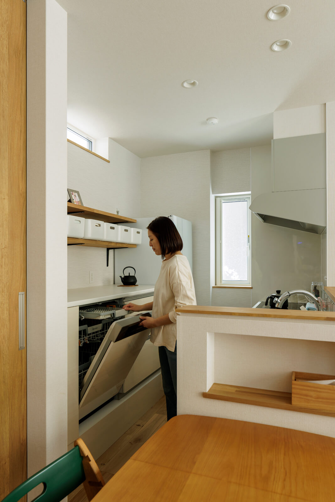 ご夫妻の要望で、キッチンの背面収納にミーレの大型食洗器を組み込んだ。洗い物の出し入れがスムーズにできるよう、天板はあえて高めに設計