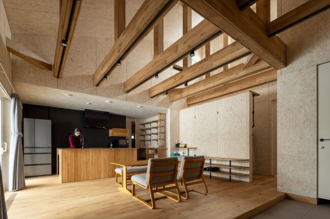 構造をダイナミックに現しにした開放感あふれるLDK。勾配天井の吹き抜けは最も高いところで6mあり、上部には採光のためにハイサイドライトを設けた