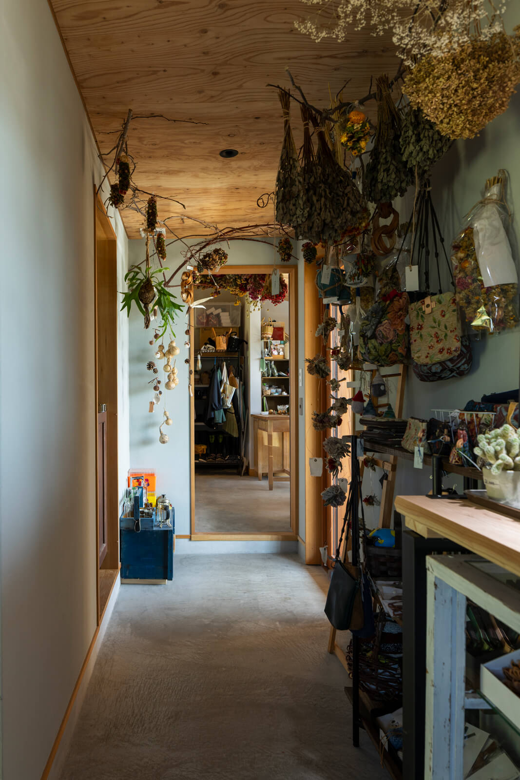 玄関を中心にパブリックとプライベート、2つの空間をつなぐ土間仕上げの廊下が延びる。居住スペースの境目には、古建具をつくり替え再利用した引き戸を設置
