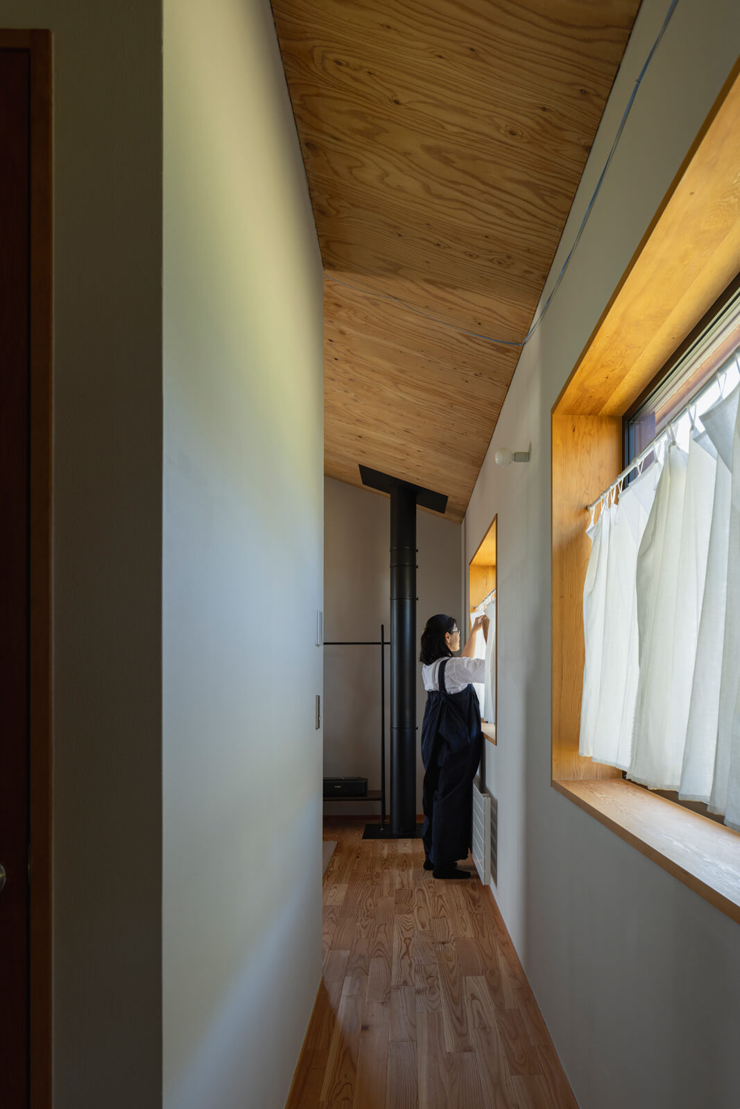 2階は家族のプライベート空間を集約。北側の庭と雑木林を望む開口を設置した廊下に沿って、次女の個室、水まわり、寝室を配置