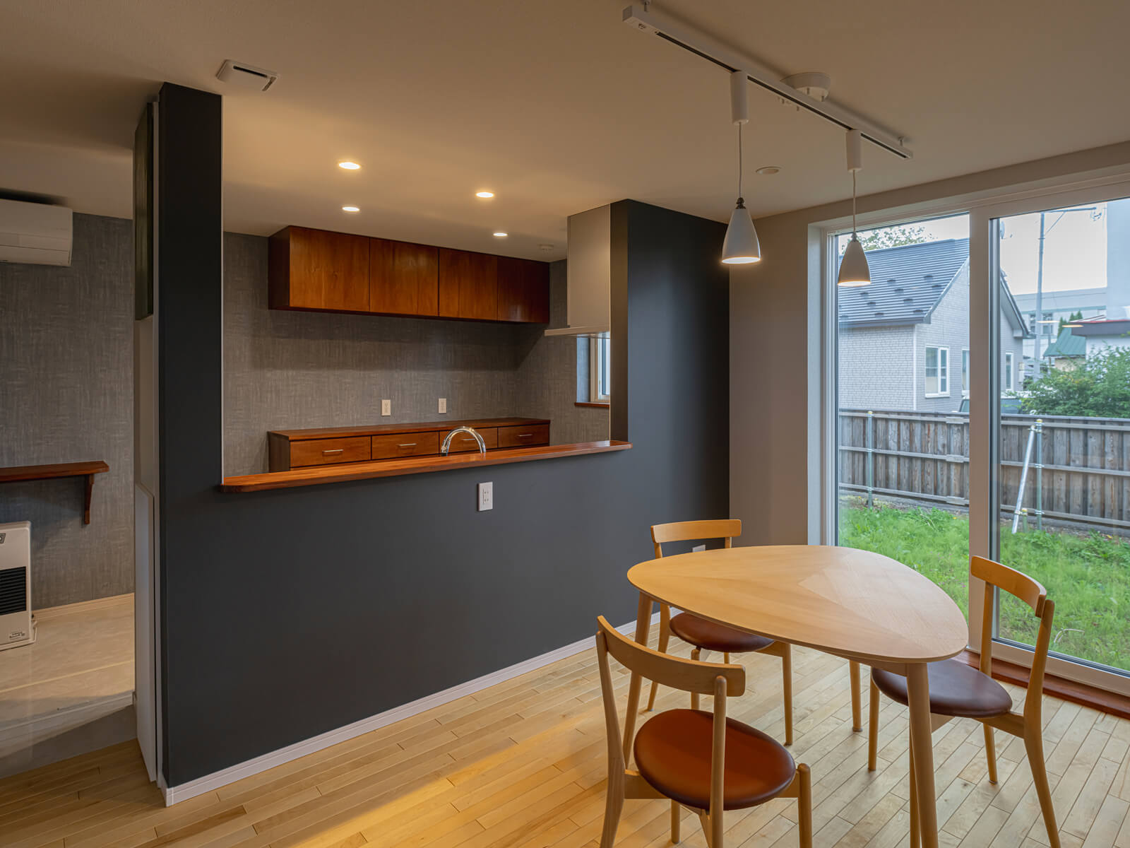 キッチンはあえてオープンではなくカウンターを高くしてカフェ風に。上部が空いているので圧迫感は感じない。大きな窓から明るい陽射しが降り注ぐダイニングから、庭に出入りできる