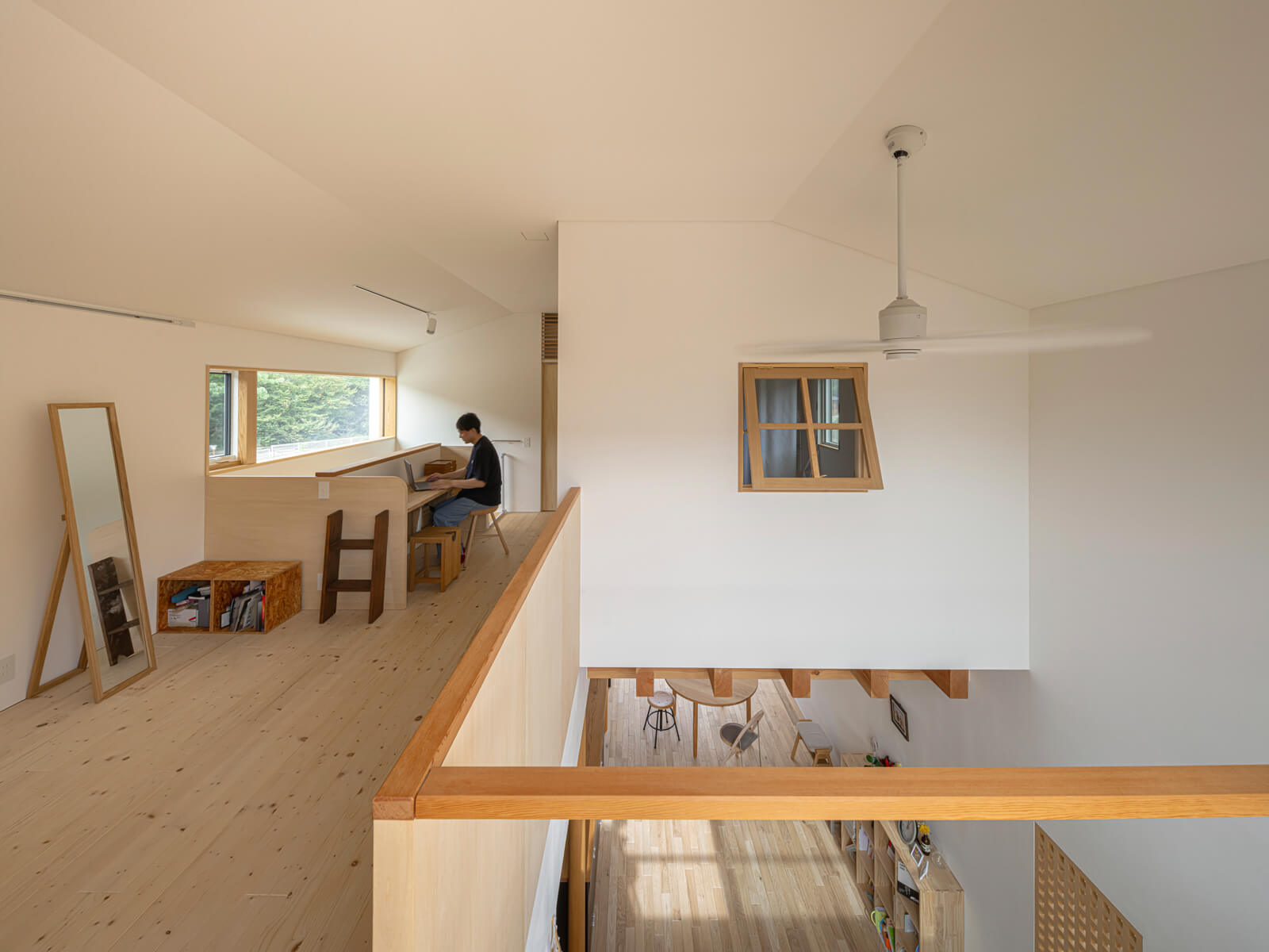 吹き抜けを通してつながる上下階。寝室も内窓を介して吹き抜けと緩やかにつながり、心地よい距離感を生み出している。2階ホール奥のスタディコーナーは、顔を上げれば窓越しに外の風景が目に入り、リフレッシュできる