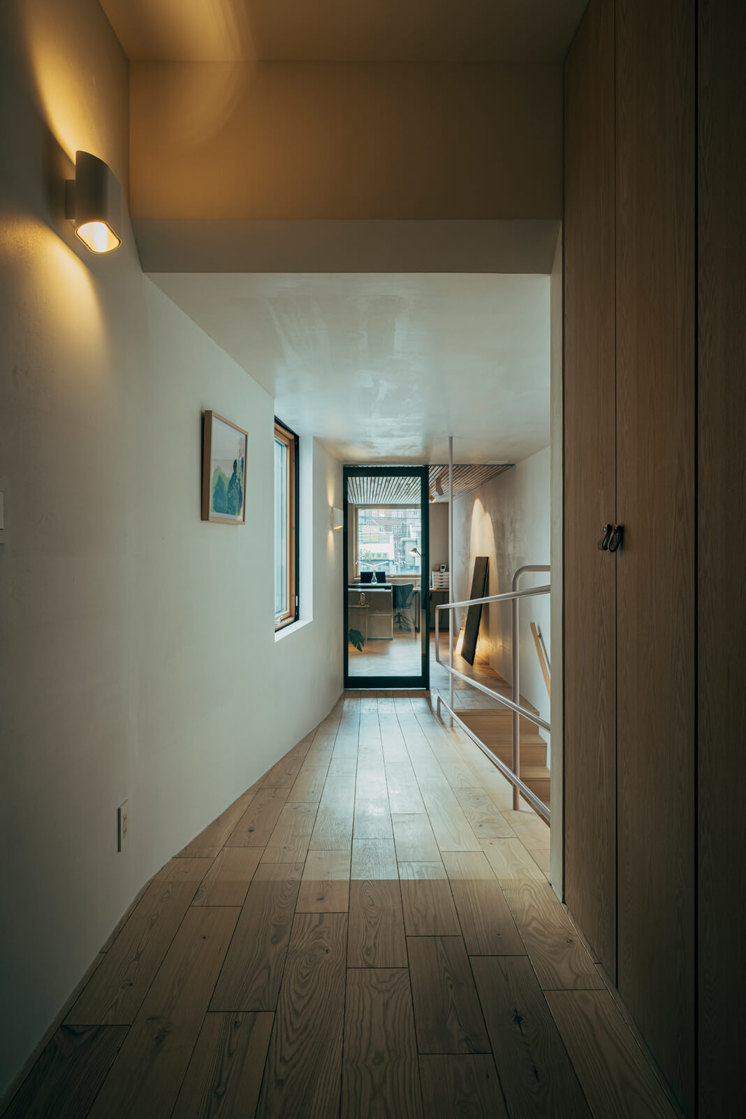 プライベートゾーンの2階は、スロープ状の廊下を中心に、奥さんのワークスペース兼趣味室と家族それぞれの個室が分けられている。手すりには細いスチールパイプを使用して、中庭に面した窓からの自然光を遮らないように配慮