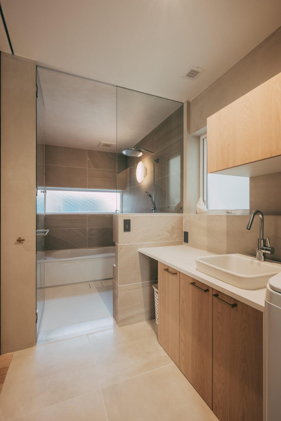 浴室とユーティリティ。洗濯物の予洗いができるように洗面ボウルよりも深めのスロップシンクを設置した。反対側にはドライルームがある