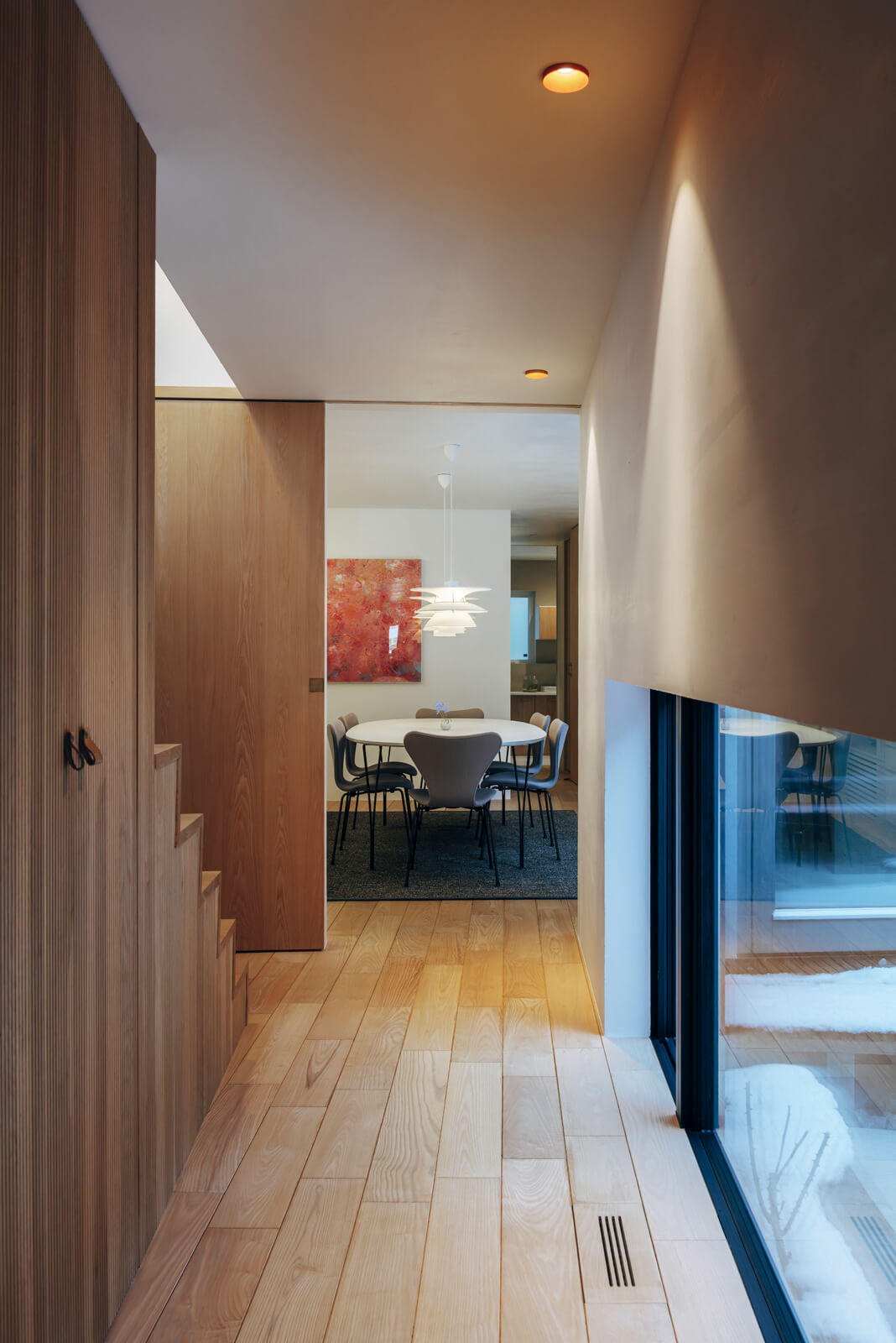 玄関からダイニング・キッチンへと続く廊下。廊下は進むにつれて徐々に幅が広くなり、帰宅した家族を温かく迎え入れる