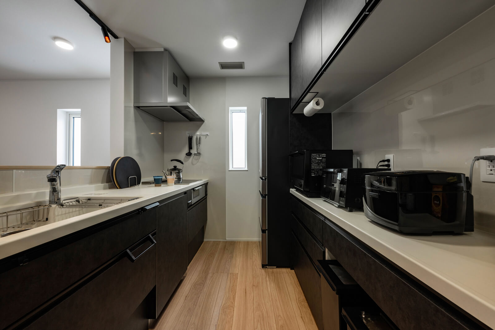 黒を基調としたシックな雰囲気のキッチン。通路の幅が1.2mほどあるので、大人二人が同時に作業をしても余裕がある