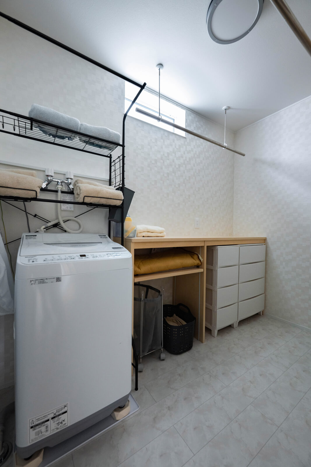 造作カウンターを備えたユーティリティ。アイロンがけができ、下着やタオルなどはそのままここで収納