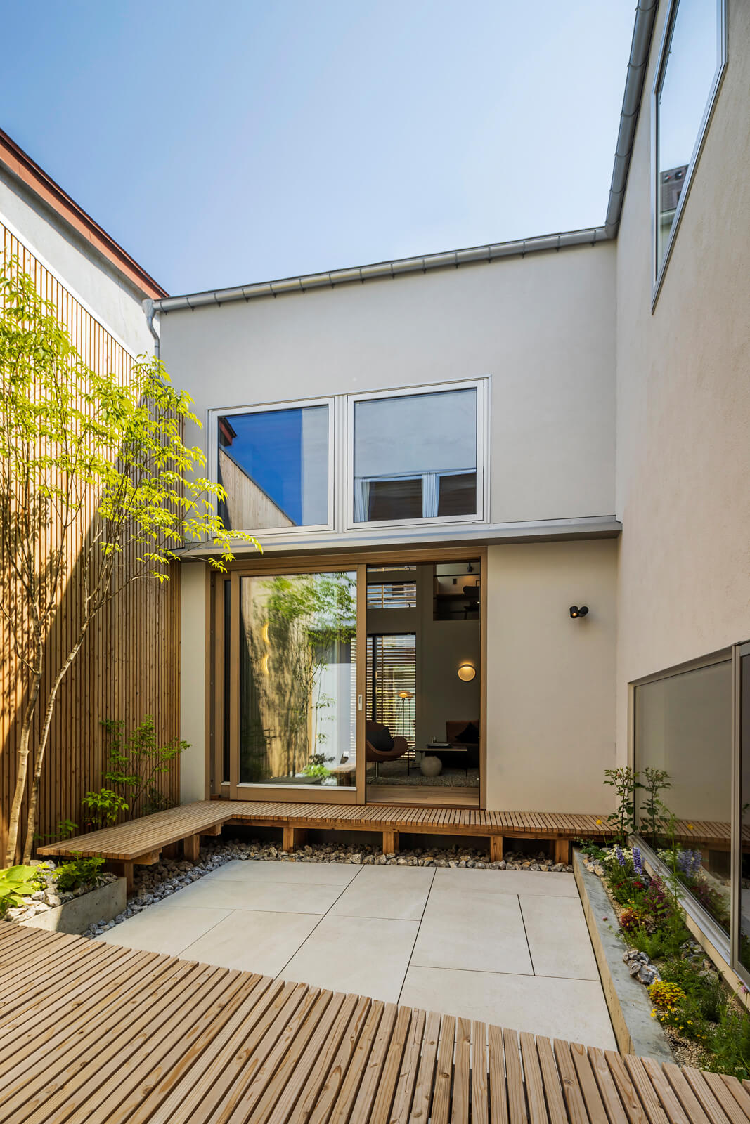 隣地との境に防火壁を設えた中庭は13帖。リビングやダイニング・キッチンから続くアウトリビングとして大人数でのBBQや、奥さんがガーデニングを楽しむ。壁の格子やウッドデッキには屋久島地杉を使用した。油分が多く、密度が高い木材で、雨や雪に強い