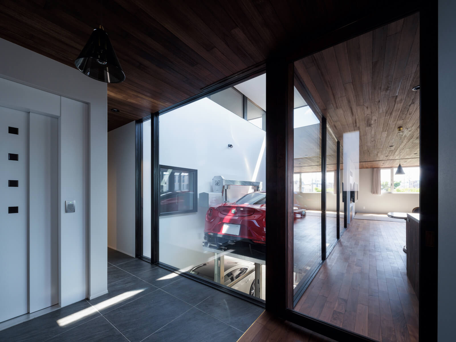 玄関からライトウェル方向を見る。スポーツタイプの自動車は冬用タイヤの設定がなく車高も低いため、冬季間はガレージに入れている