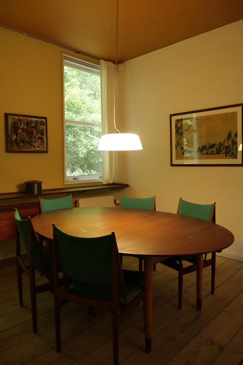 背もたれと座面を緑のファブリックで仕上げたEgyptian Chairが並ぶダイニング。テーブルの天板はチーク材で、銀の象嵌が施されている