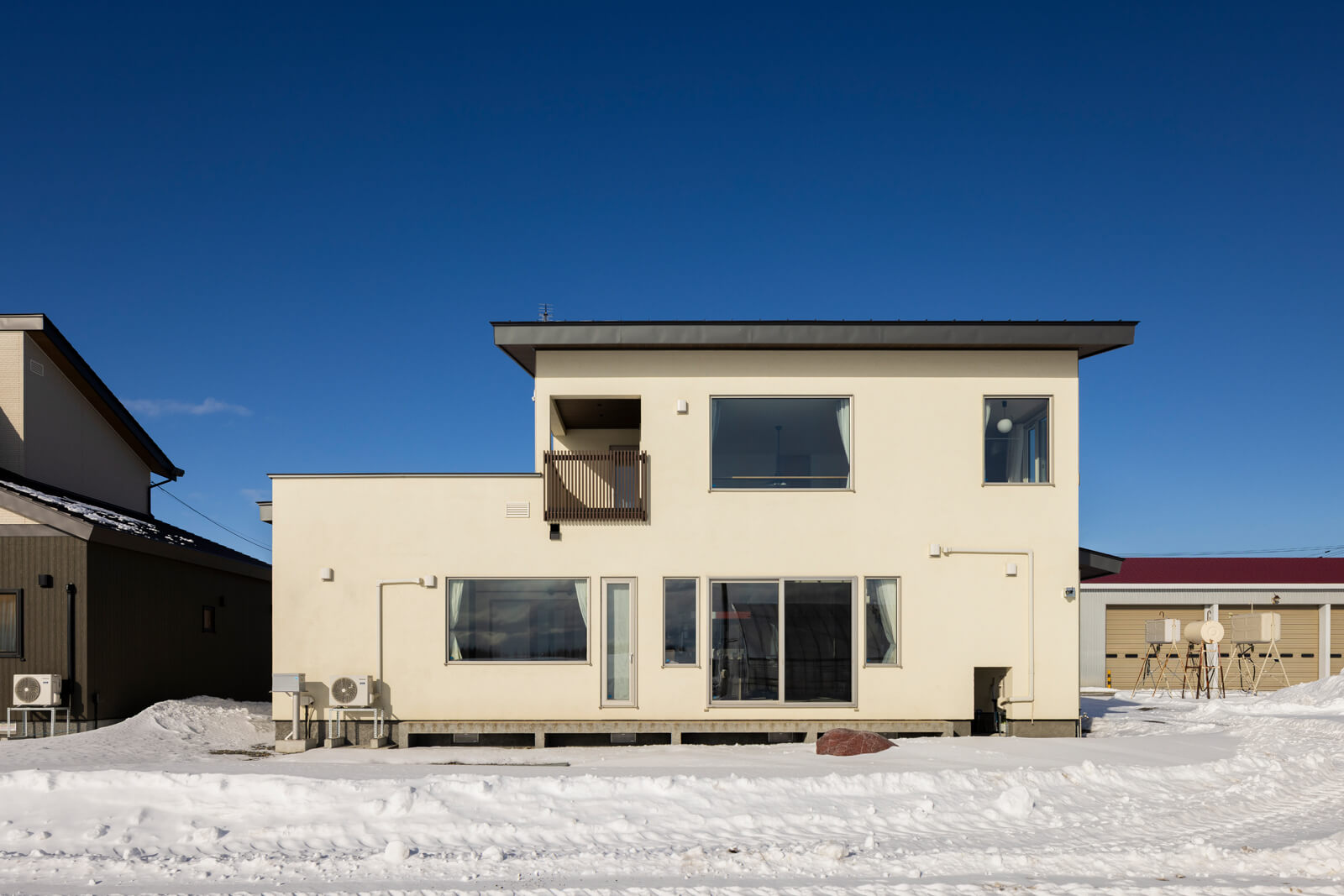 南面に塗り壁を採用し、直線的なフォルムに温かなニュアンスをまとわせた外観