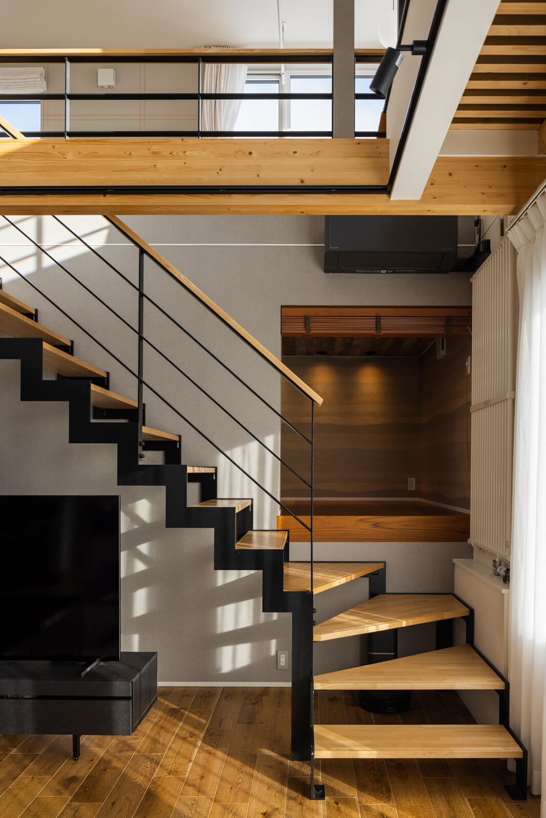 リビング階段はアイアンを採用した造作仕様。中二階にはKさんの趣味スペースを設けた