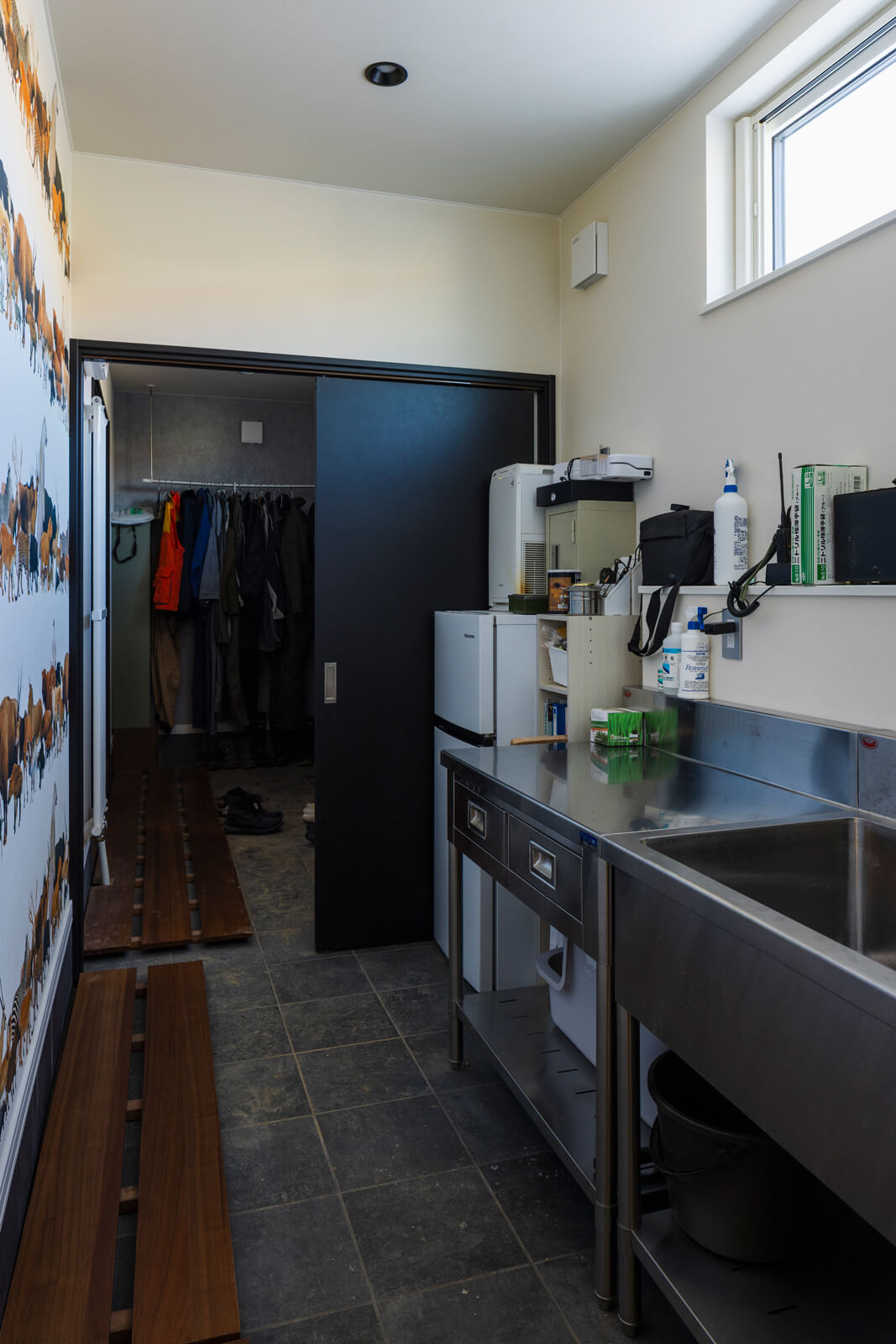作業着のまま出入りできる農家玄関は、ユーティリティへ最短の動線でつながる。隣接して、狩猟免許を持つKさんの要望で、シカ肉の処理や加工専用のスペースを設けた
