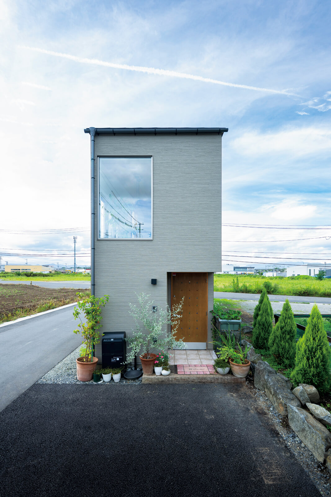 東側に設けた玄関側からの外観。木製の玄関ドアと2階の大きな窓が印象的