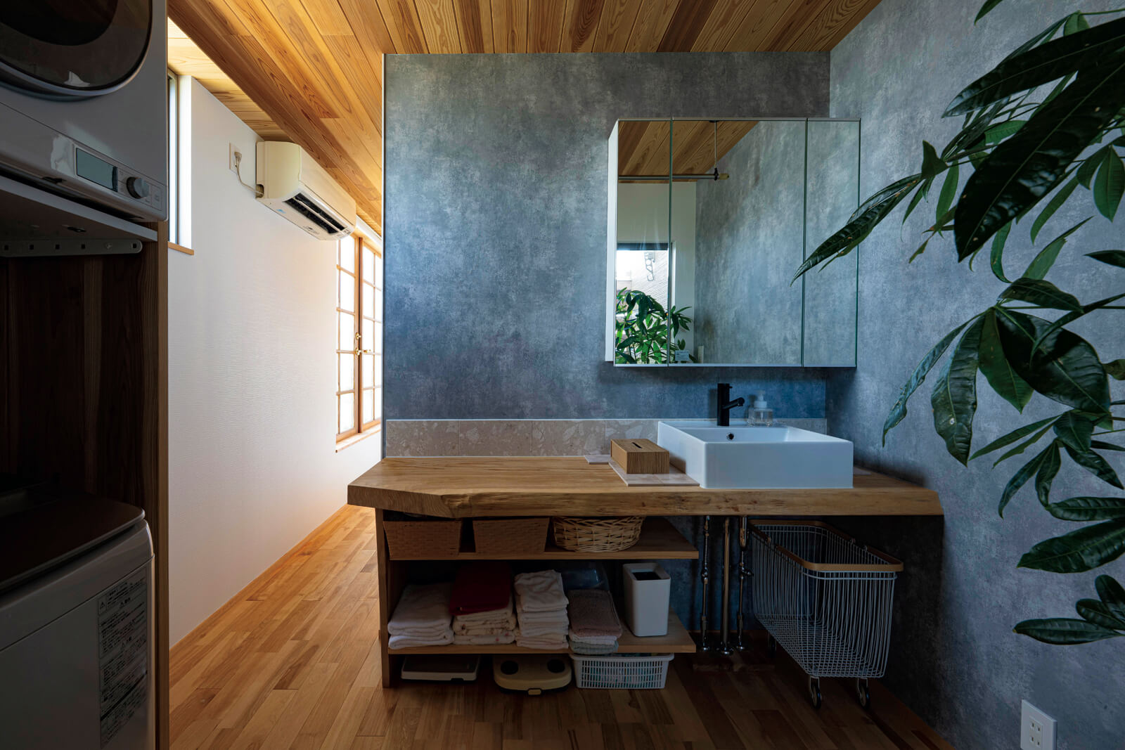 2階の奥に配した洗面脱衣室。カウンターは厚みのある一枚板を用いて造作した