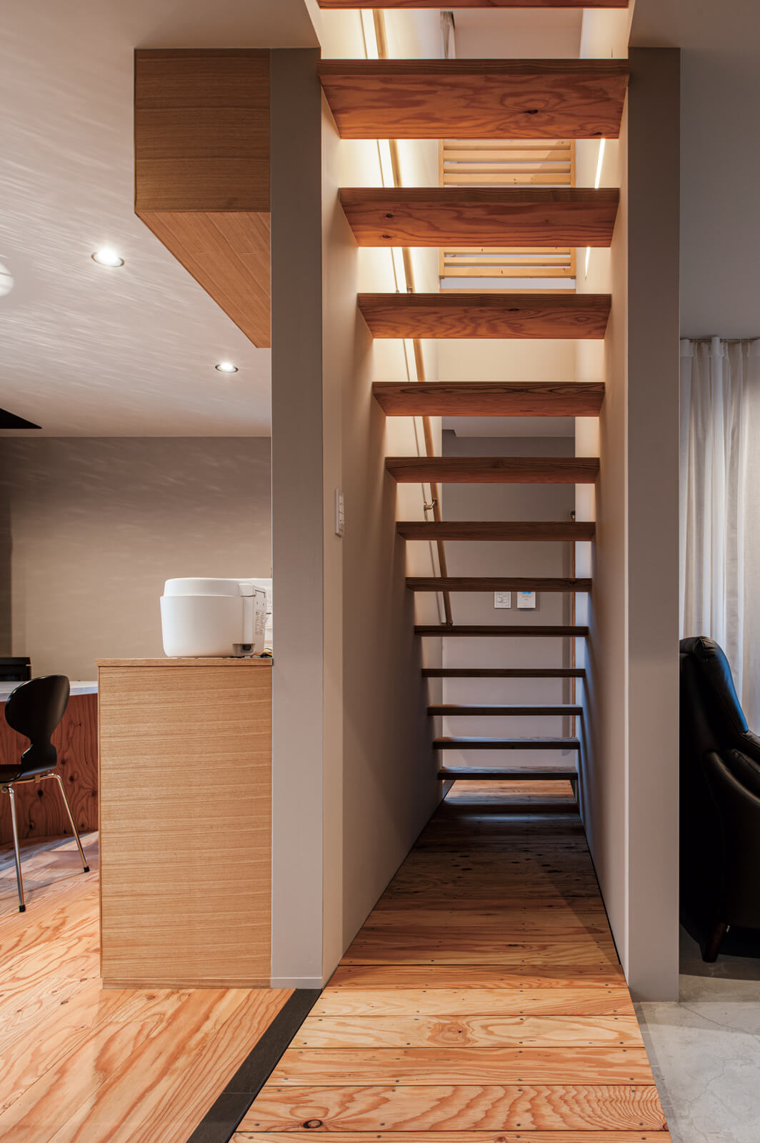 1階土間とダイニング・キッチンの針葉樹合板の床の間には、同じ材で造作したすのこを配置し、足元から緩やかに空間を分離