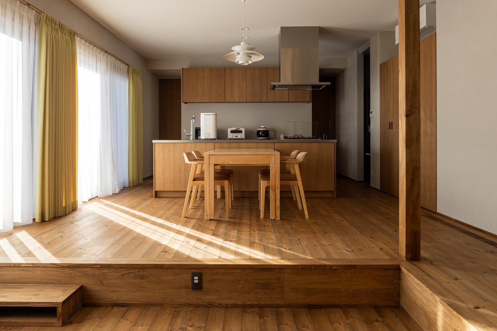 パイン無垢材とナラが優しいハーモニーを奏でるダイニング・キッチン。空間のポイントにと嶋代表の提案でルイス・ポールセンのPHランプをダイニングに、モザーをリビングに採用した