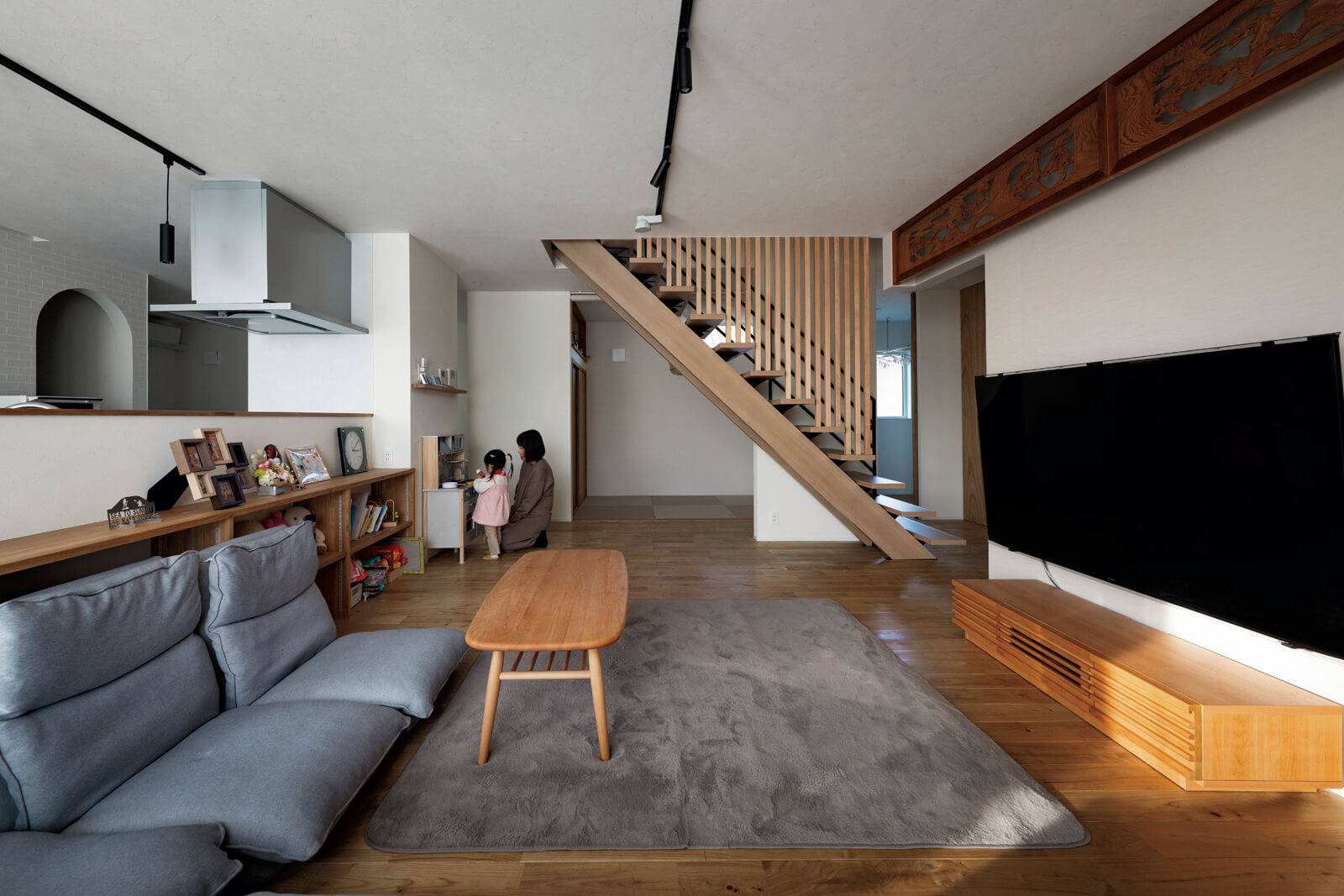 リビングを中心に、キッチンやダイニング、畳コーナー、土間スペースがつながる。旧居の気配が空間に落ち着きを与える