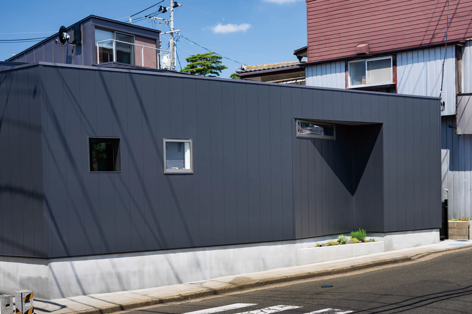 交差点側にユーティリティをまとめ、街の景観に呼応するシンプルな外観デザインとした