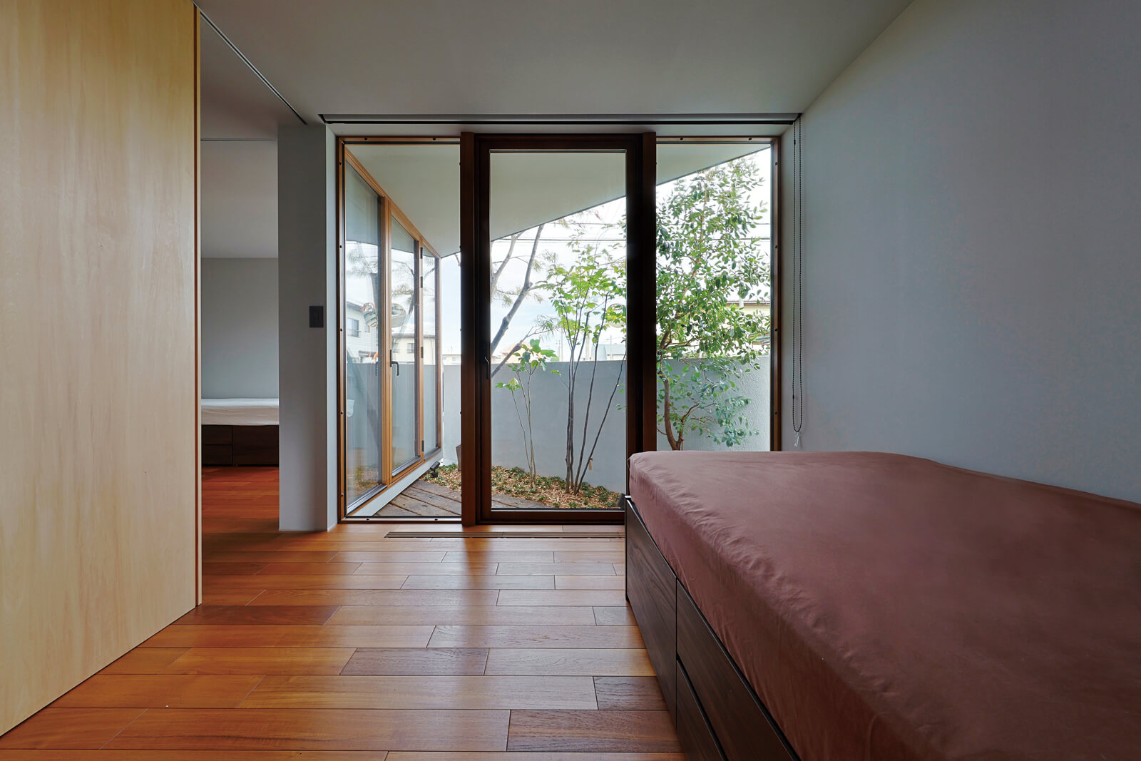 寝室からは既存の樹木を生かした坪庭を楽しめる